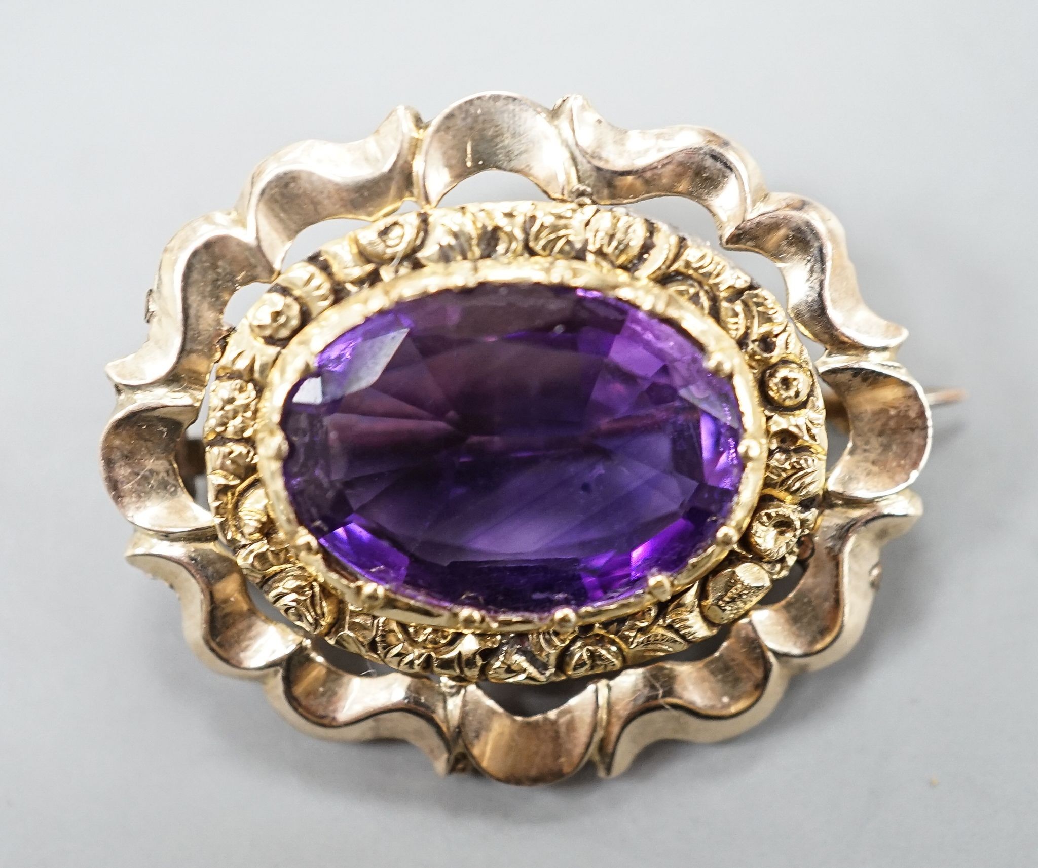 A yellow metal and amethyst set brooch, 29mm, gross 5.7 grams.